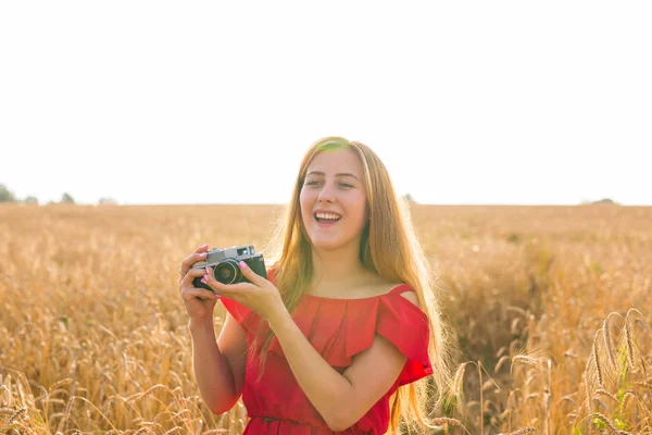 Fotógrafa femenina en el campo con una cámara tomando fotos — Foto de Stock