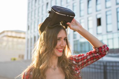 Sanal gerçeklik kulaklık bir kentsel bağlamda giyen güzel genç kadın