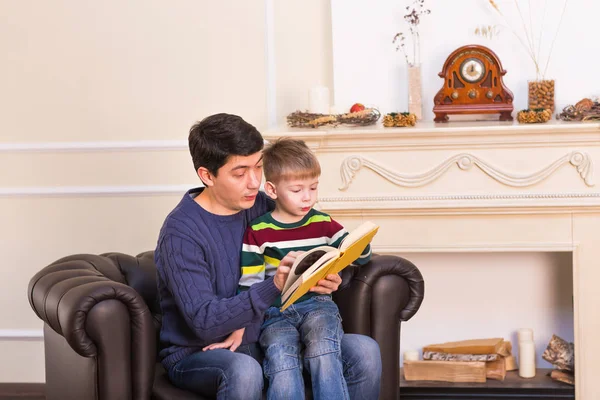 Pai e filho lendo livro de história juntos — Fotografia de Stock