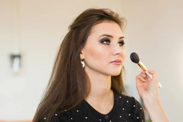 Młoda piękna kobieta stosując makijaż przez make-up artysta — Zdjęcie stockowe