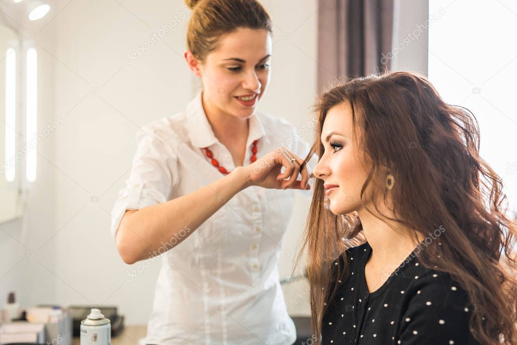 Beautiful woman getting haircut by hairdresser in the beauty salon.