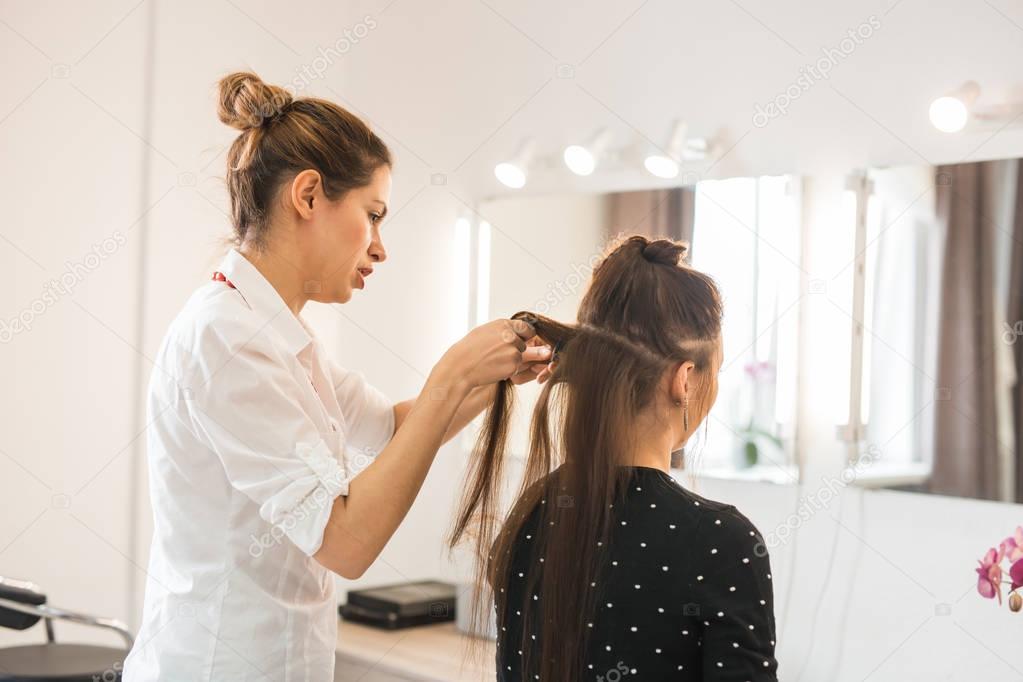 Beautiful woman getting haircut by hairdresser in the beauty salon.