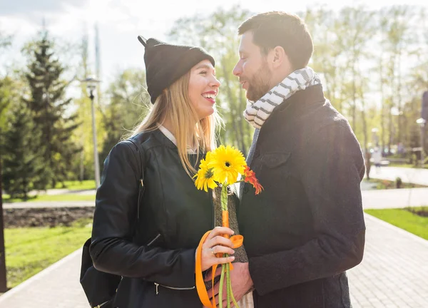 Gravid kvinna med man och bukett Gerbera — Stockfoto