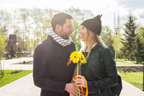 Gravid kvinna med man och bukett Gerbera — Stockfoto