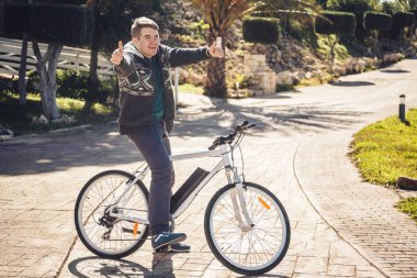 Binicilik bisiklet park gösteren başparmak erkek genç