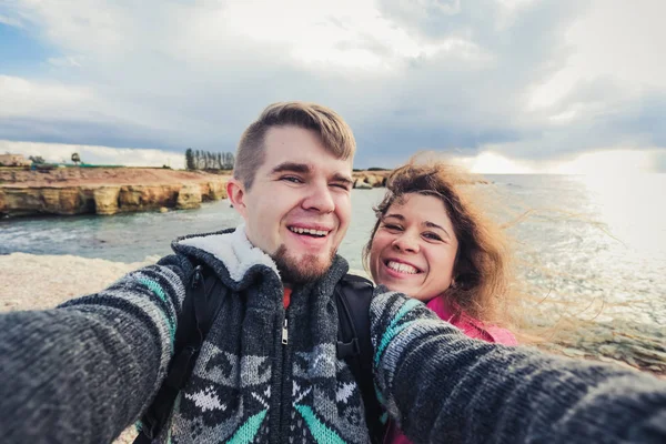 Nos encanta viajar. Selfie Aventura. Caucásico joven pareja tomando selfie mientras caminando en las montañas cerca del mar . — Foto de Stock