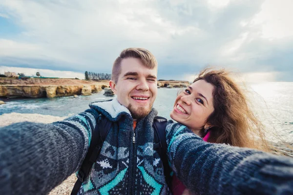 Unga lyckliga paret tar selfie foto på semester nära havet. — Stockfoto