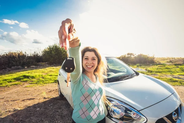 Glückliche Autofahrerin hält Autoschlüssel in der Nähe ihres neuen Autos — Stockfoto