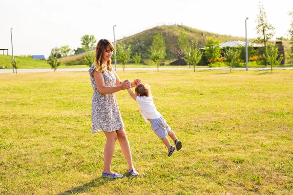 Щаслива мати грає зі своїм сином у парку — стокове фото