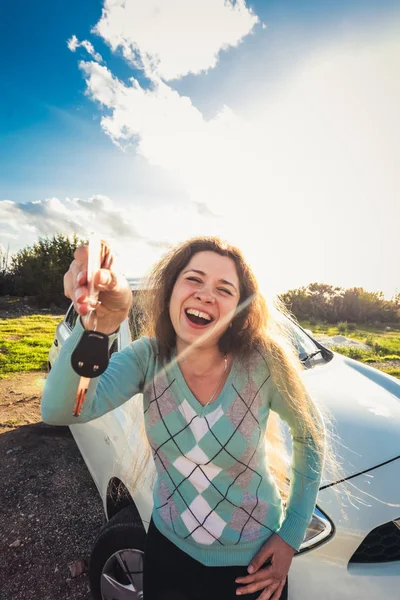 Erfolgreiche schöne glückliche Frau im neuen Auto mit Schlüsseln - im Freien — Stockfoto