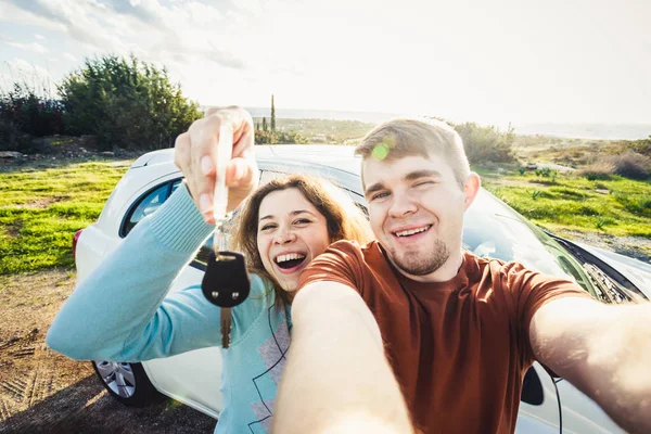 Mutlu güzel çift showingh portresi arabanın yakınında duran tuşları — Stok fotoğraf