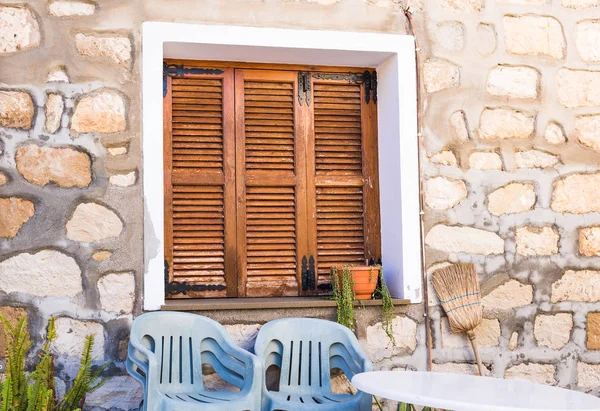 Persianas de janela de madeira marrom rústico com fundo de parede de pedra velha . — Fotografia de Stock