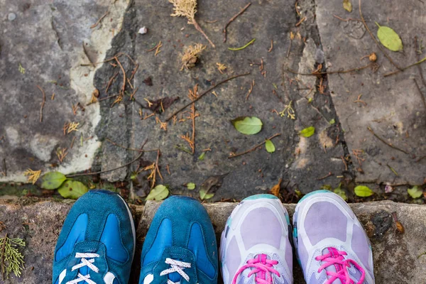 Uppifrån ett två par sneakers skor på gatsten — Stockfoto