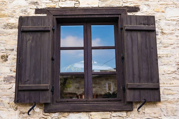 Rustic brown wooden window shutters with old stone wall background. — Stock Photo, Image