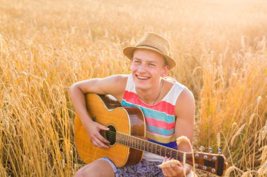 adam açık havada akustik gitar çalmak