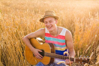 adam açık havada akustik gitar çalmak