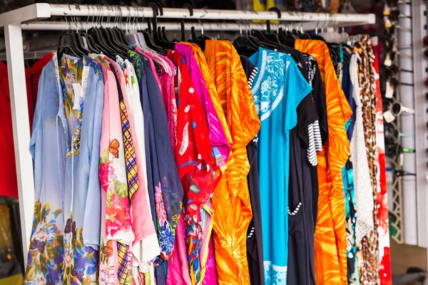 Farbenfrohe Kleidung hängt in Markt oder Geschäft Hintergrund. — Stockfoto