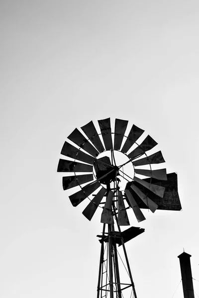 stock image Silhouette of a working vintage country Windmill in sunset light or twilight.