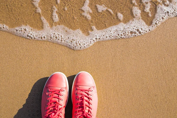 Koncept s růžové tenisky na světlé moře písku. Moře letní dovolené pozadí s místem pro text — Stock fotografie