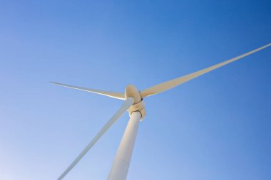 Mavi gökyüzü ile elektrik üreten rüzgar türbini - enerji koruma kavramı