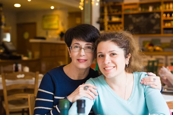 Liefde voor moeder en dochter. Gelukkig vrouwen in een leuk café met kopie ruimte op onscherpe achtergrond. Leeftijd vrouw en haar volwassen dochter in café. Moederdag. — Stockfoto