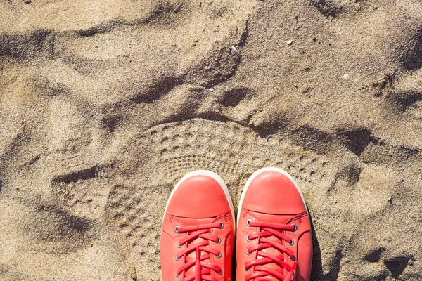 Concept with pink sneakers on bright sea sand. Summer vacation background with space for the text — Stock Photo, Image