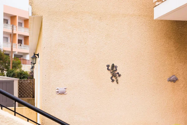 Lagarto cerâmico engraçado anexado à parede de estuque da casa rural. Detalhe arquitetônico da casa típica no país mediterrâneo — Fotografia de Stock