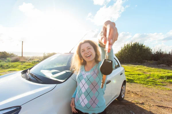 Automatisk business, bil försäljning, konsumism och människor koncept - lycklig kvinna anläggning ny bilnyckel utomhus — Stockfoto