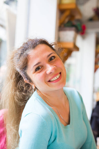 Close-up portrait of an attractive young woman smiling indoors