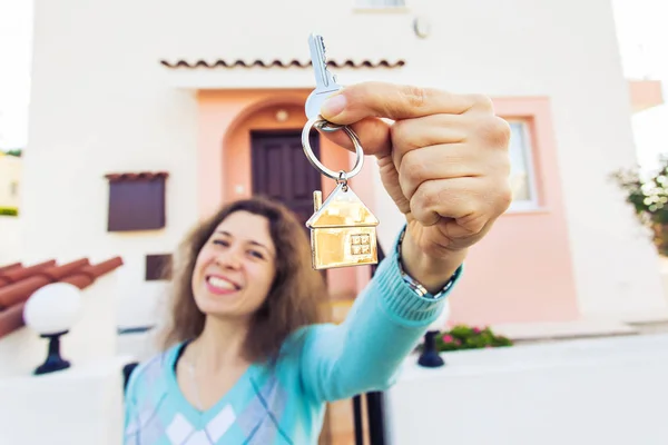 Mujer joven feliz en frente de la nueva casa con llaves de la nueva casa —  Fotos de Stock