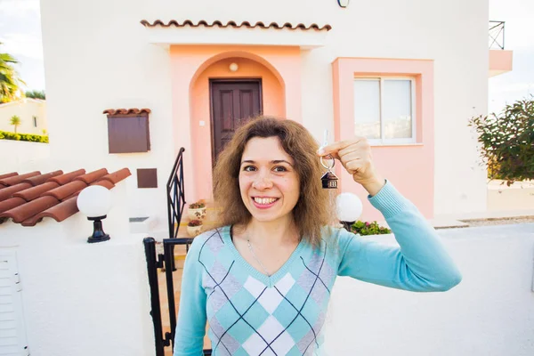 Ευτυχισμένος νεαρή γυναίκα μπροστά από νέο σπίτι με νέο σπίτι κλειδιά — Φωτογραφία Αρχείου