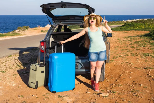 Reise, Sommerferien und Urlaubskonzept - junge Frau mit Koffer auf Autofahrt. — Stockfoto