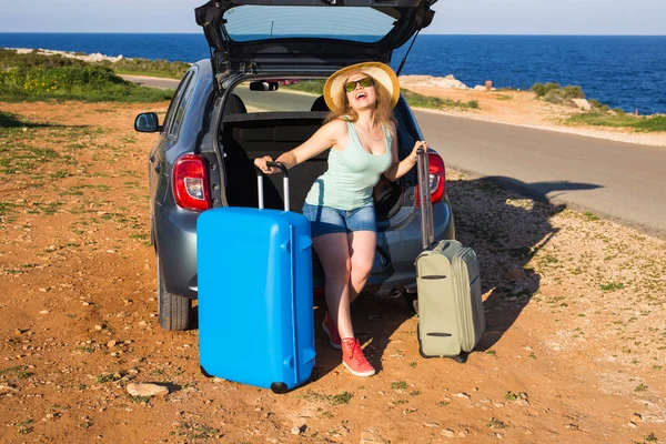 Cestování, letní prázdniny a dovolené koncepce - mladá žena s kufry na cestě autem. — Stock fotografie