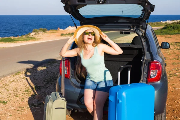 Reise, Sommerferien und Urlaubskonzept - junge Frau mit Koffer auf Autofahrt. — Stockfoto