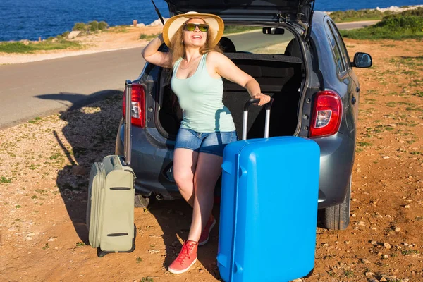 Reise, Sommerferien und Urlaubskonzept - junge Frau mit Koffer auf Autofahrt. — Stockfoto