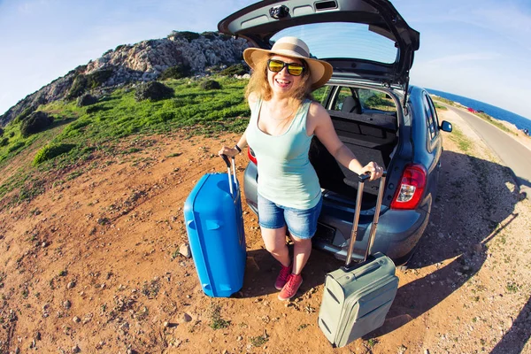 Cestování, letní prázdniny a dovolené koncepce - mladá žena s kufry na cestě autem. — Stock fotografie