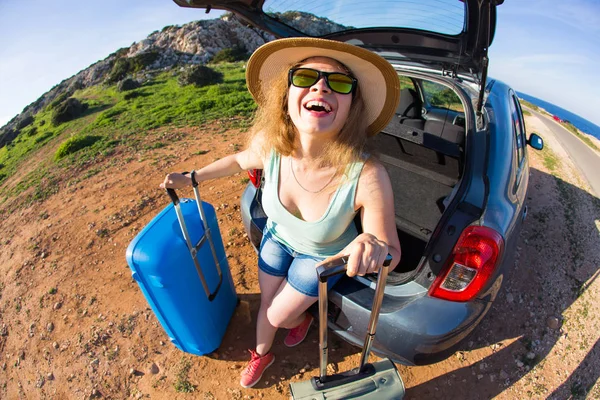 Reise, Sommerferien und Urlaubskonzept - junge Frau mit Koffer auf Autofahrt. — Stockfoto