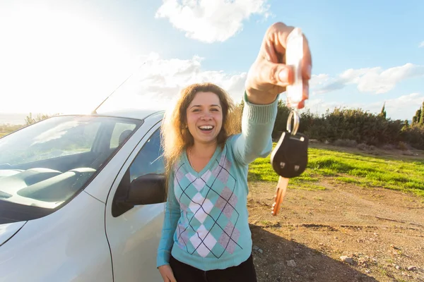 Glückliche Autofahrerin zeigt Autoschlüssel auf dem Hintergrund ihres Autos — Stockfoto