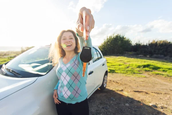 Negocio del automóvil, venta de coches, consumismo y concepto de la gente - mujer feliz sosteniendo nueva llave del coche al aire libre — Foto de Stock