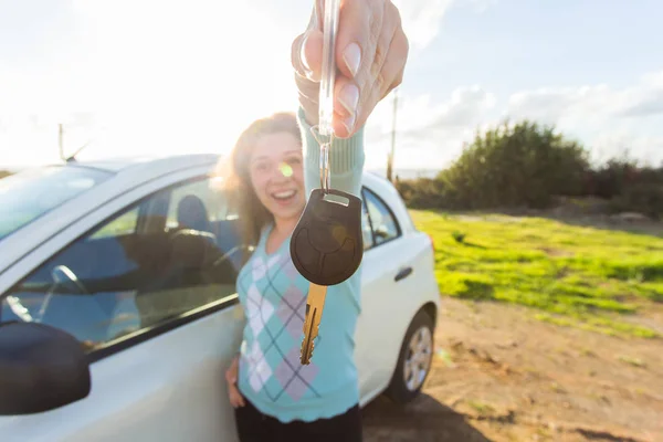 Glückliche Autofahrerin zeigt Autoschlüssel auf dem Hintergrund ihres Autos — Stockfoto