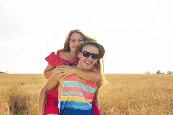 Feliz casal se divertindo ao ar livre no campo. Conceito de Liberdade. Piggyback. . — Fotografia de Stock