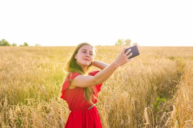 teknoloji, genç kadın alarak selfie yanında smartphone tahıl alanda gülümseyen yaz tatil, tatil ve insanlar kavramı-.