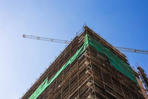 Bouwkraan en gebouw in aanbouw tegen blauwe lucht — Stockfoto