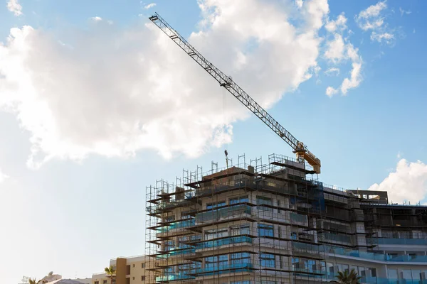 Bouwkraan en gebouw in aanbouw tegen blauwe lucht — Stockfoto