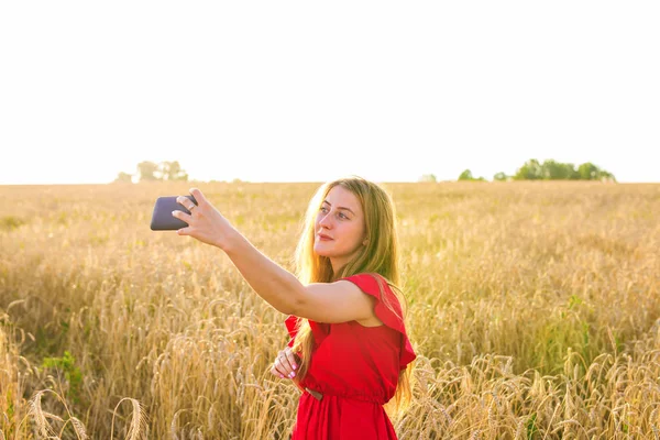 Retrato de una joven sonriente haciendo foto selfie en el campo —  Fotos de Stock