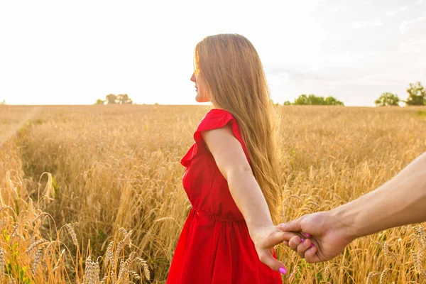 Pojďte za mnou, krásná mladá žena drží ruku člověka v pšeničné pole — Stock fotografie