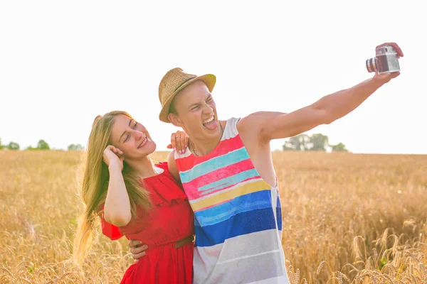 Junges glückliches Paar macht ein Selfie auf dem Feld — Stockfoto