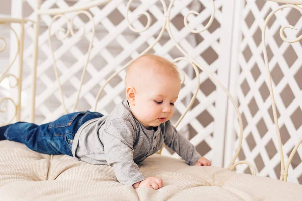 Adorable bebé en el dormitorio soleado. Niño recién nacido relajándose. Guardería infantil para niños pequeños.Mañana familiar en casa. Niñito acostado boca abajo —  Fotos de Stock