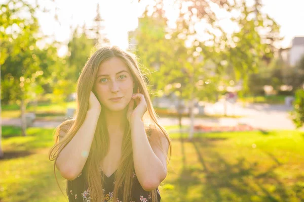 Retrato de una joven hermosa mujer. Retrato de cerca de una joven y hermosa modelo posando al aire libre. Retrato de verano al aire libre —  Fotos de Stock