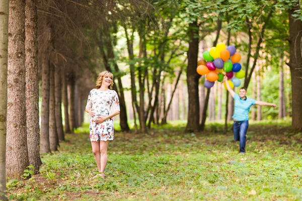 Feliz família grávida se divertindo durante a caminhada na natureza verão . — Fotografia de Stock